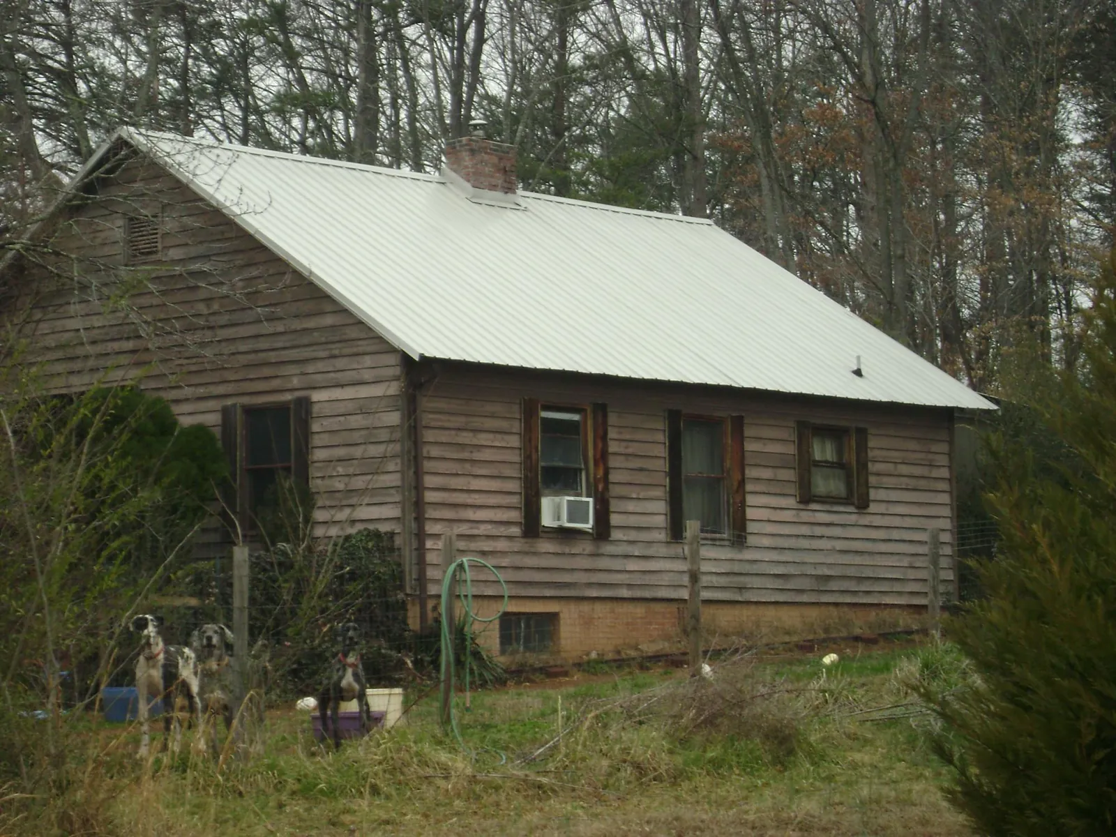 White metal roof on an old wood sided farmhouse, from a Metal Roof Installation job in Castalia